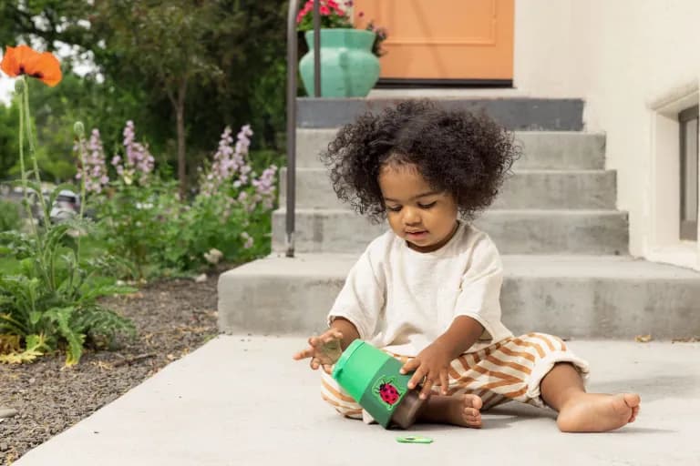 Child outside playing with the Fuzzy Bug Shrub from The Adventurer Play Kit